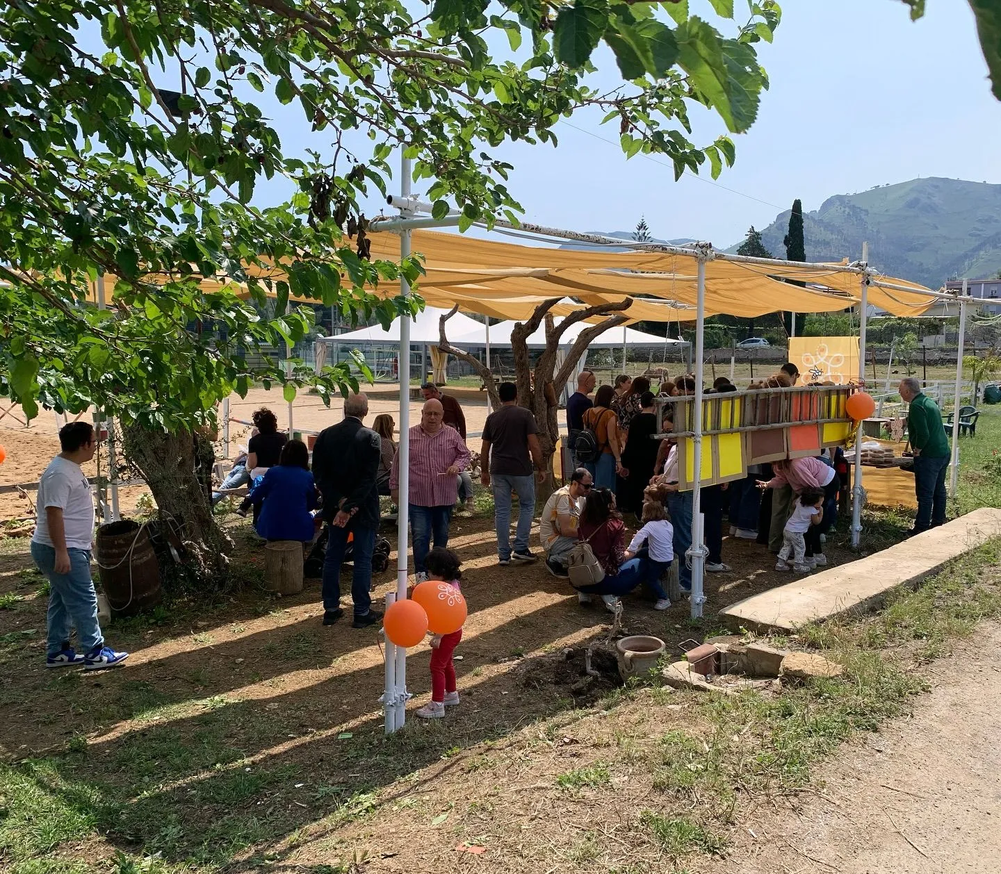 Visitors under the apiary pergola during a Mielerie Aperte open day